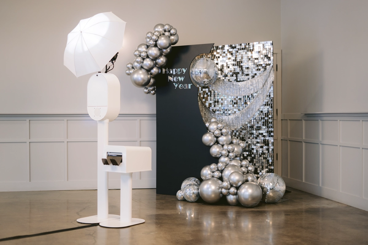 Photo booth setup with a custom event backdrop